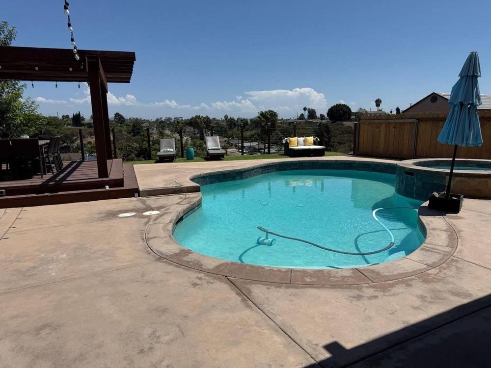 Swept outdoor patio deck with wiped furniture cushions and clean exterior glass doors in San Diego